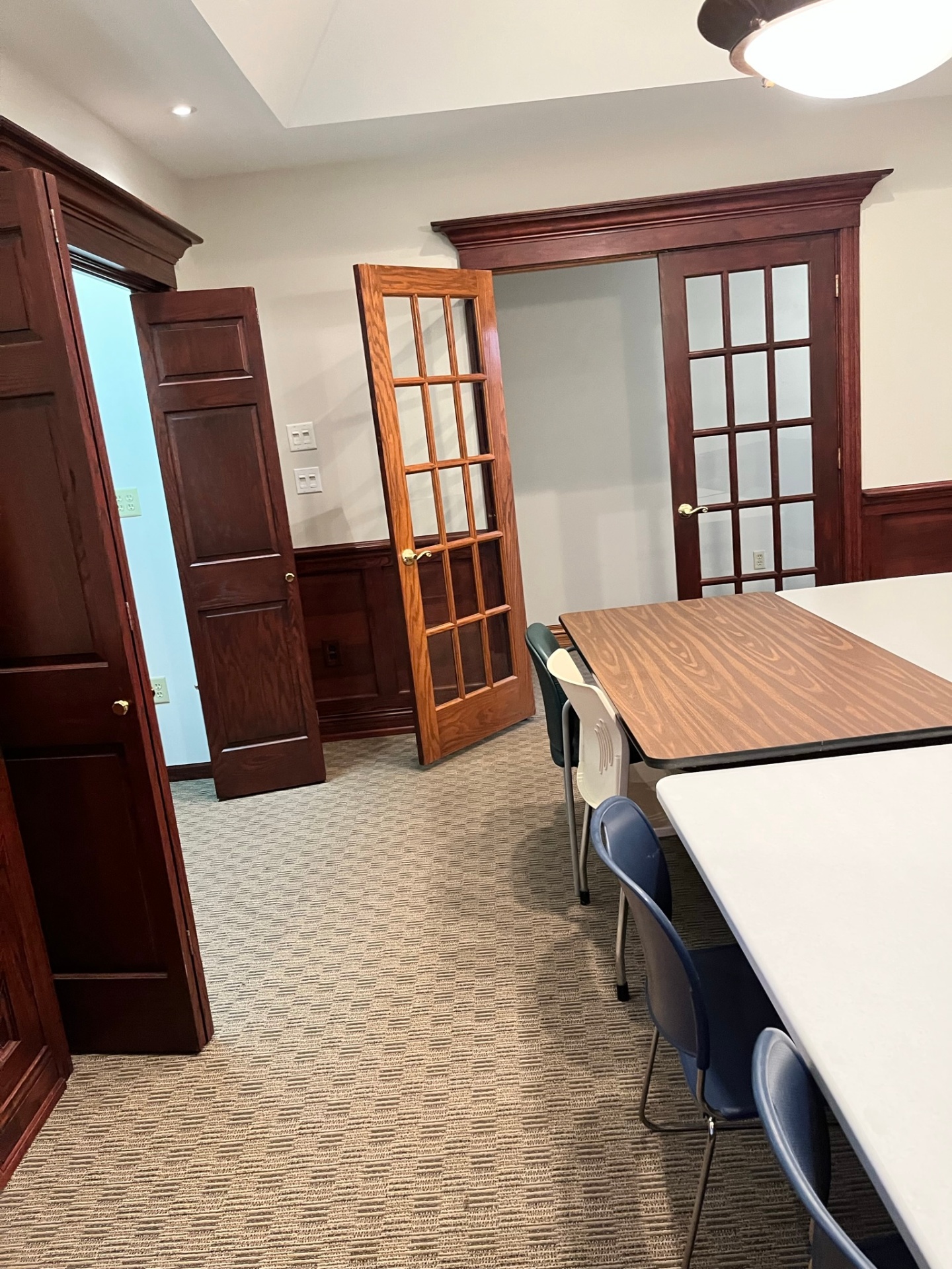 Clean corporate boardroom with polished wood table and chairs